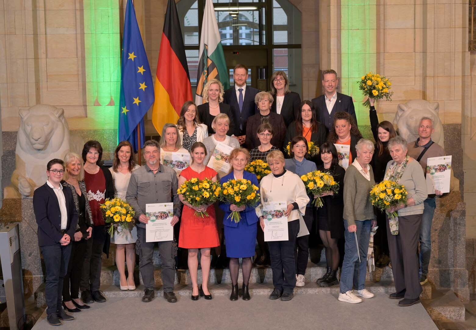 Mehrere Menschen posieren auf einer Treppe für ein gemeinsames Gruppenbild